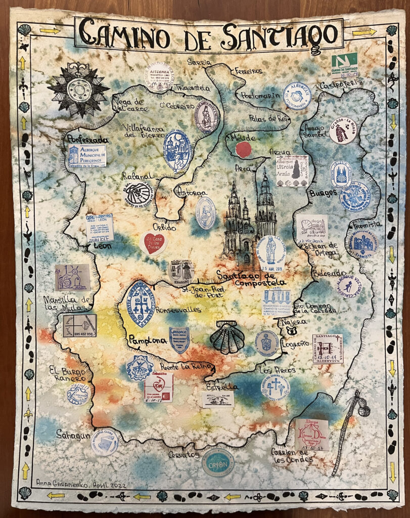 Watercolor and pen map titled "Camino De Santiago" at the top in old style hand lettering with decorative boarder, ornate campus rose, hand drawn path that leads to a drawing of a church, and photocopies of rubber stamps to mark the stops