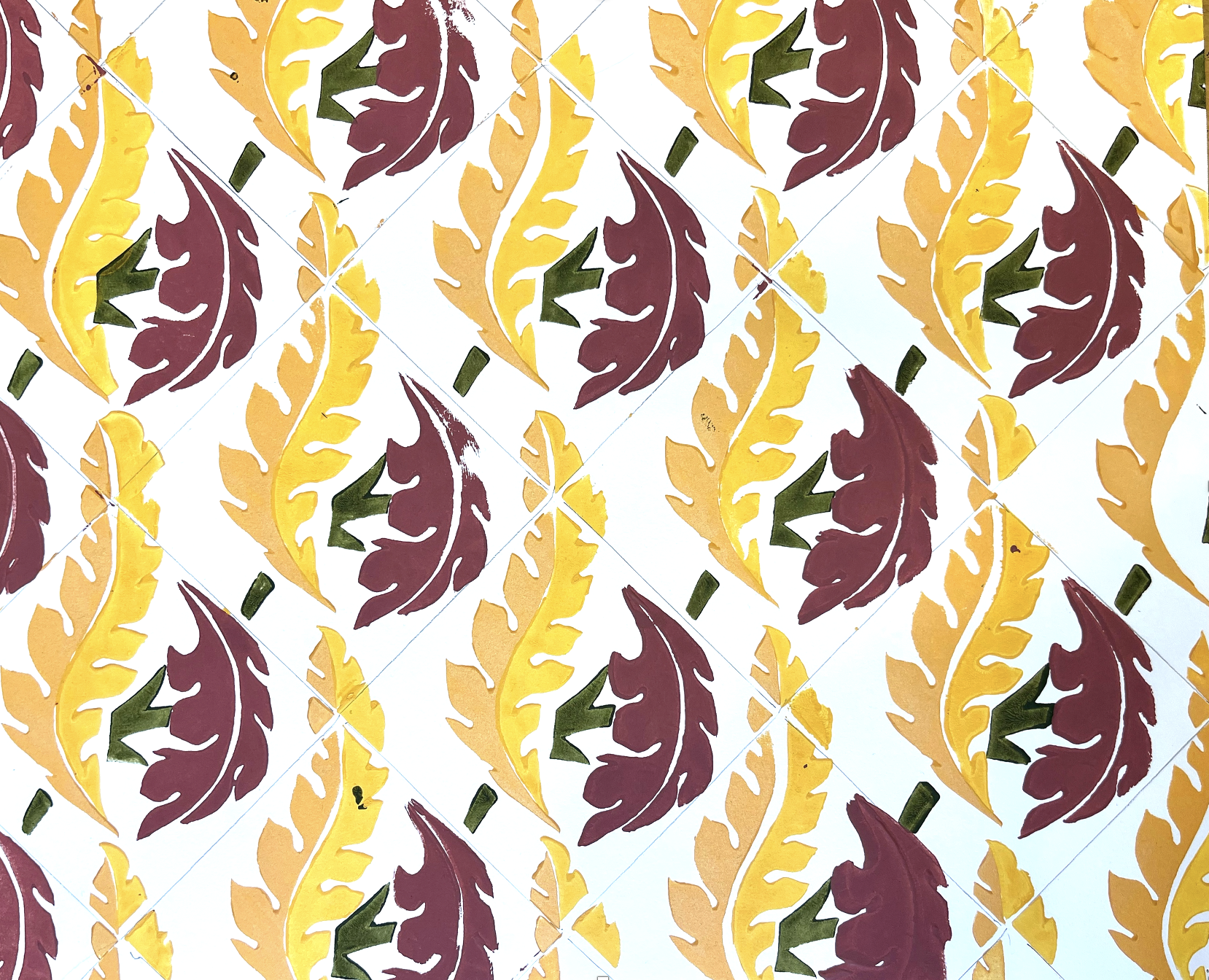 abstracted feather pattern in a diamond repeat block printed in yellow, dark red, and olive green.